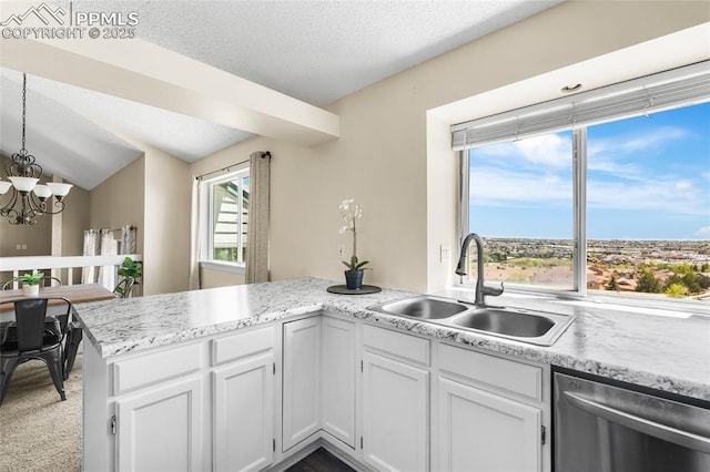 kitchen with dishwasher, a sink, white cabinetry, a chandelier, and a peninsula