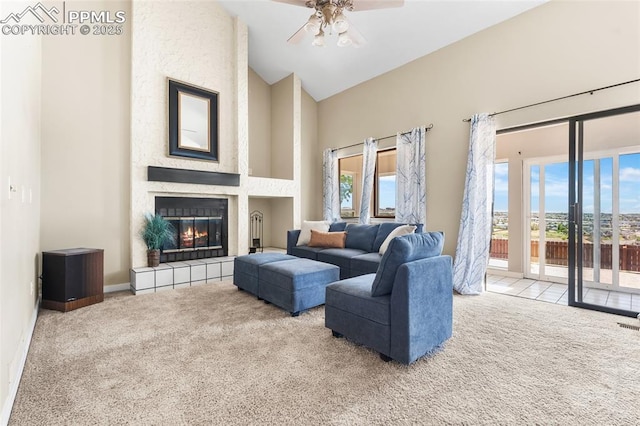 living room with carpet, high vaulted ceiling, a ceiling fan, a tile fireplace, and baseboards