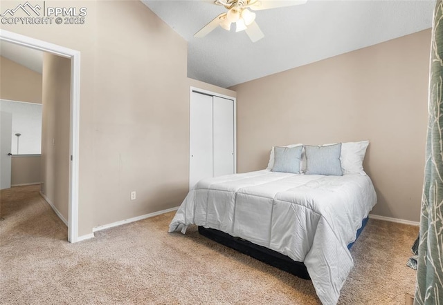 carpeted bedroom featuring vaulted ceiling, a closet, baseboards, and a ceiling fan