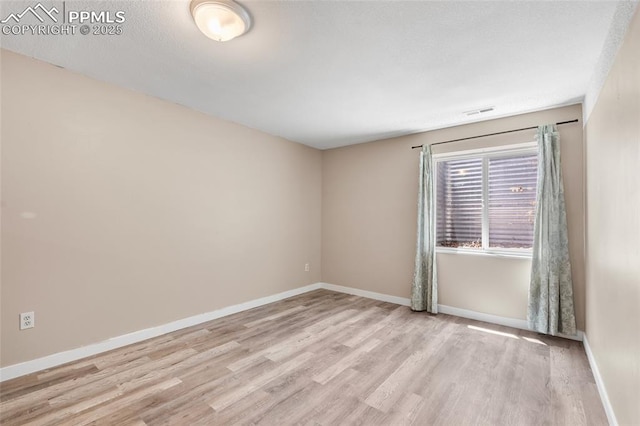 spare room with wood finished floors and baseboards