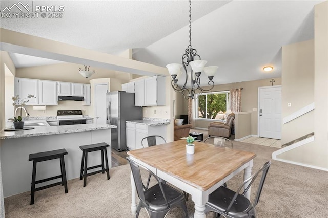 dining room featuring vaulted ceiling, light carpet, and a chandelier