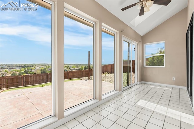 unfurnished sunroom featuring vaulted ceiling, tile patterned floors, and baseboards