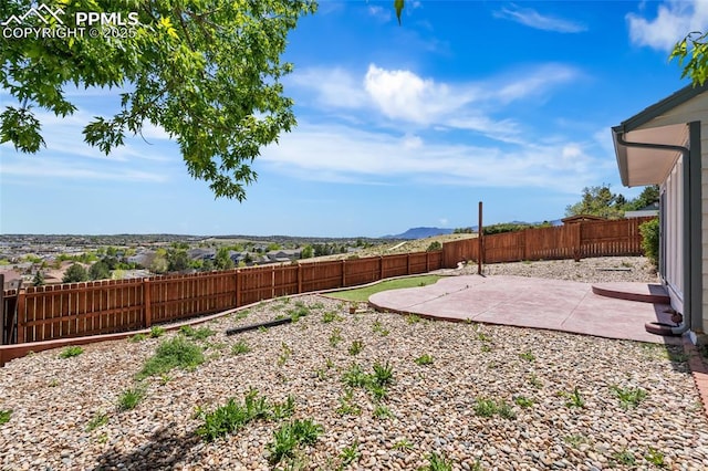 fenced backyard with a patio area and a mountain view