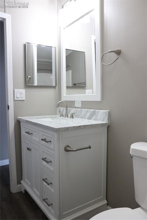 4663 Pine Marten Pt, Colorado Springs, CO 80922 - bathroom with toilet, wood finished floors, and vanity