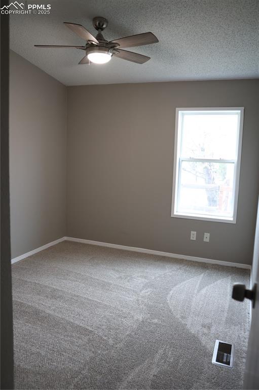 4663 Pine Marten Pt, Colorado Springs, CO 80922 - spare room with visible vents, baseboards, ceiling fan, a textured ceiling, and carpet
