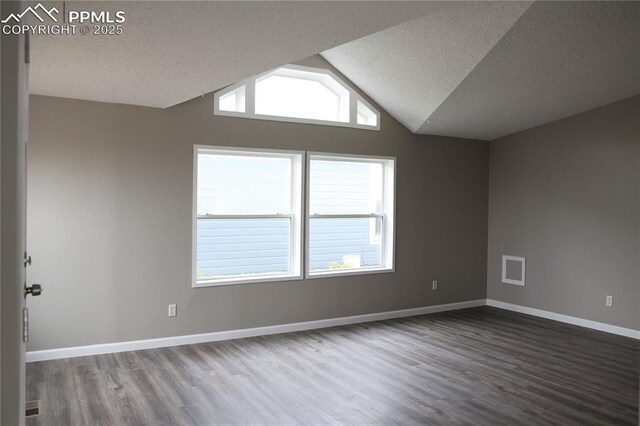 4663 Pine Marten Pt, Colorado Springs, CO 80922 - spare room featuring baseboards, a textured ceiling, wood finished floors, and lofted ceiling
