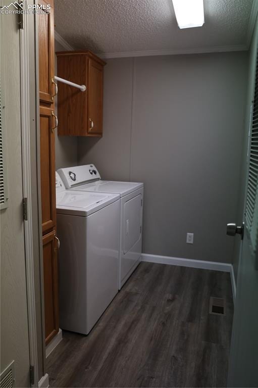 4663 Pine Marten Pt, Colorado Springs, CO 80922 - laundry area with ornamental molding, dark wood-style flooring, a textured ceiling, washing machine and clothes dryer, and cabinet space