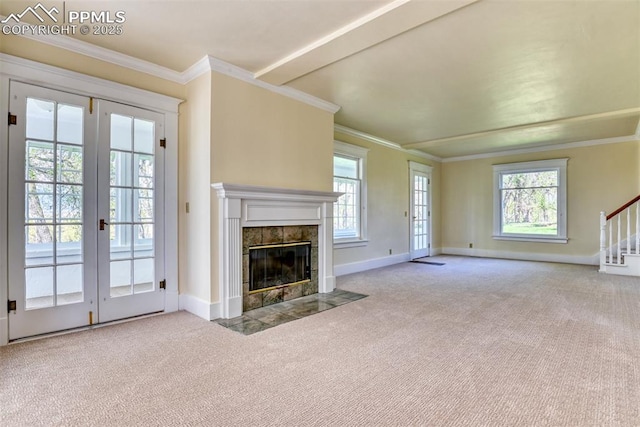 unfurnished living room with french doors, a fireplace, crown molding, carpet floors, and baseboards