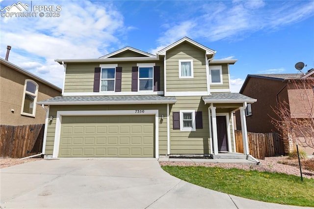 traditional home with fence, driveway, and a garage