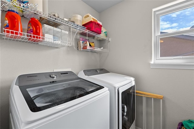 washroom featuring washer and dryer, laundry area, and a healthy amount of sunlight