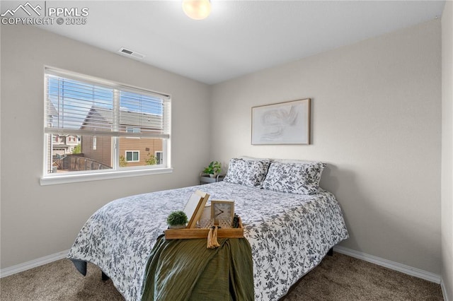 carpeted bedroom featuring visible vents and baseboards