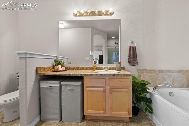 full bathroom featuring vanity, a bath, and toilet