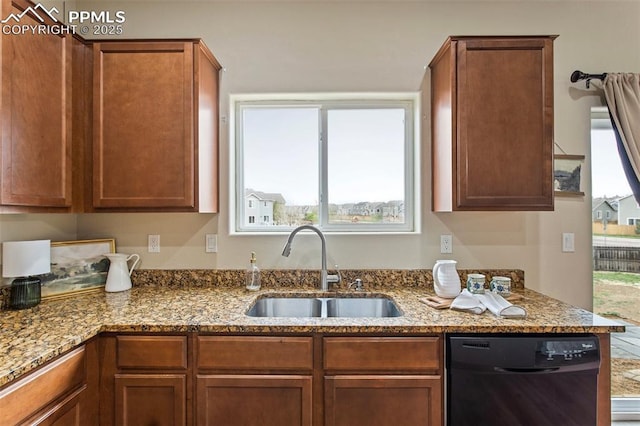 kitchen featuring brown cabinetry, a sink, stone counters, and dishwasher