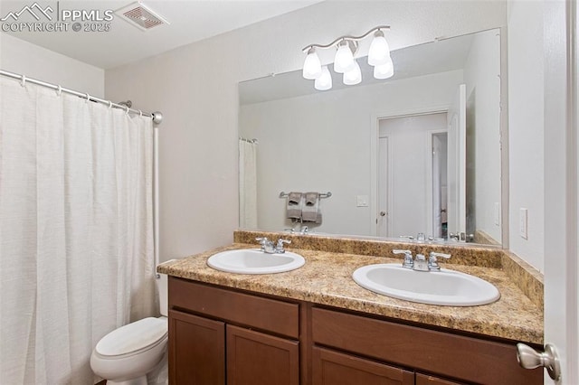 full bathroom featuring double vanity, toilet, visible vents, and a sink