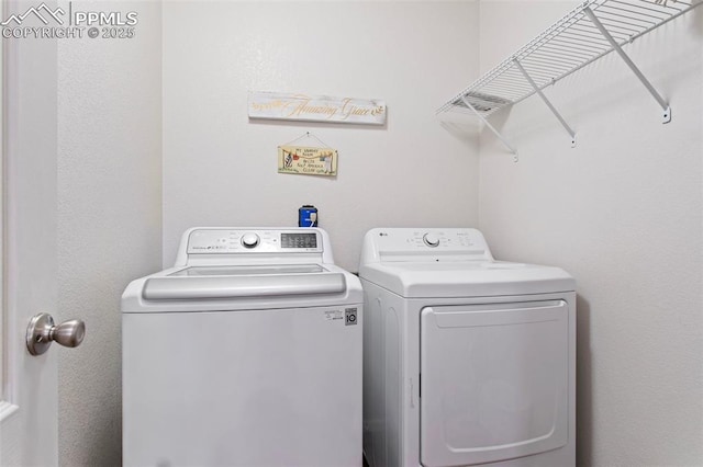 laundry area with washing machine and clothes dryer and laundry area