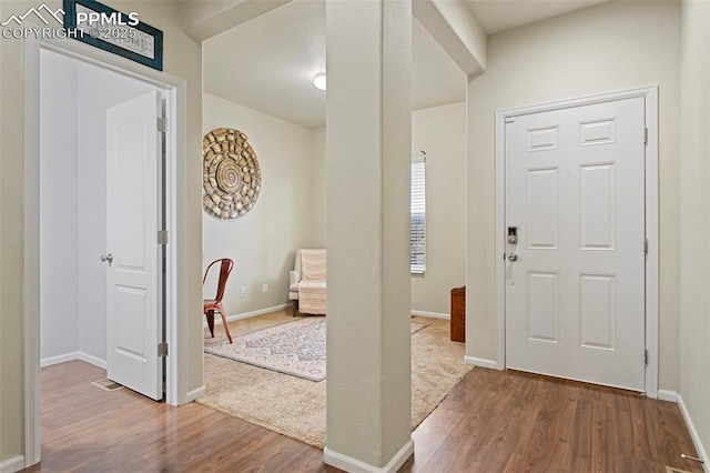 foyer featuring baseboards and dark wood-style floors