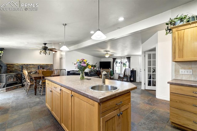 3235 S Meridian Rd, Colorado Springs, CO 80929 - kitchen featuring stone finish floor, ceiling fan, tasteful backsplash, a sink, and open floor plan
