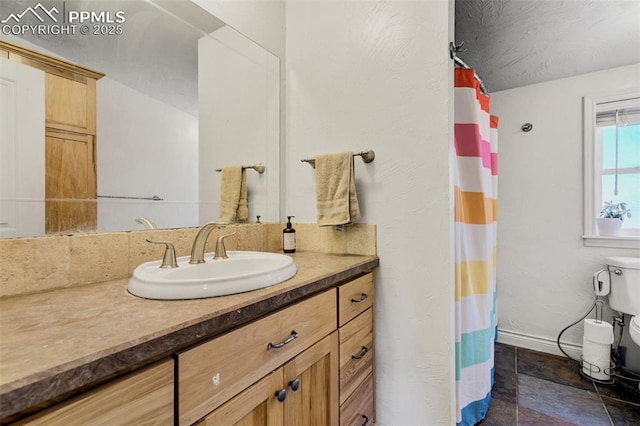 3235 S Meridian Rd, Colorado Springs, CO 80929 - full bath with vanity, curtained shower, toilet, baseboards, and stone finish floor