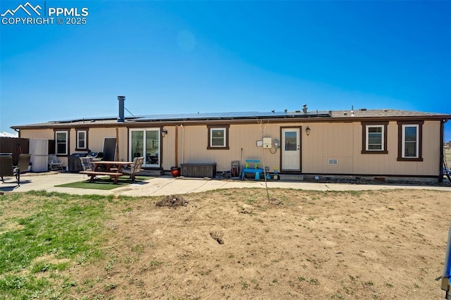 3235 S Meridian Rd, Colorado Springs, CO 80929 - back of property with entry steps, roof mounted solar panels, and a patio area