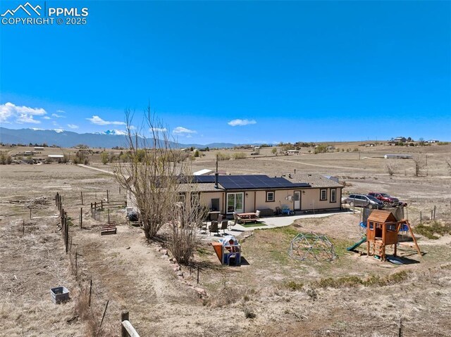 3235 S Meridian Rd, Colorado Springs, CO 80929 - rear view of property with a patio, a playground, a rural view, a mountain view, and solar panels