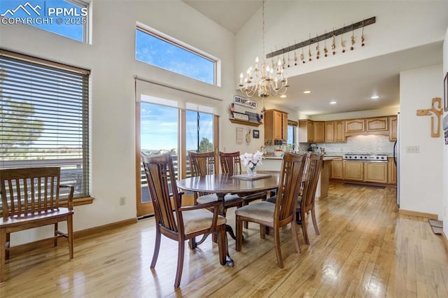 7850 Wilderness Dr, Colorado Springs, CO 80908 - dining area with a high ceiling, light wood-style floors, a chandelier, baseboards, and recessed lighting