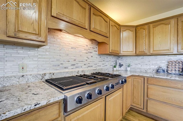 7850 Wilderness Dr, Colorado Springs, CO 80908 - kitchen featuring stainless steel gas stovetop, tasteful backsplash, light stone countertops, and light wood-style floors