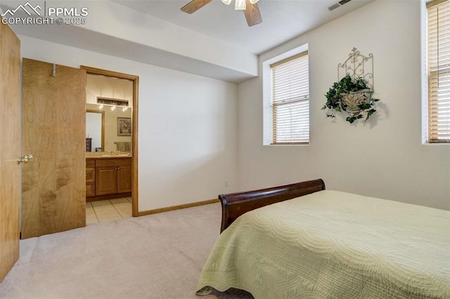 7850 Wilderness Dr, Colorado Springs, CO 80908 - carpeted bedroom with connected bathroom, tile patterned flooring, a ceiling fan, and baseboards