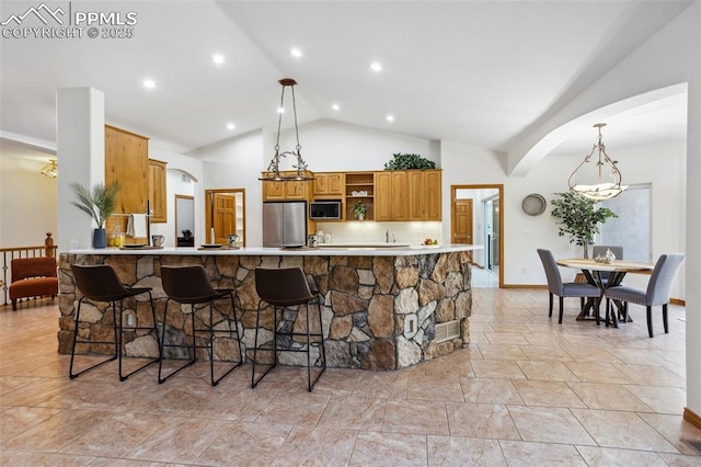 4415 Hidden Rock Rd, Colorado Springs, CO 80908 - kitchen featuring stainless steel appliances, open shelves, a kitchen bar, pendant lighting, and high vaulted ceiling