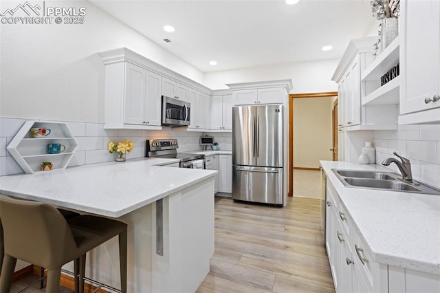 4415 Hidden Rock Rd, Colorado Springs, CO 80908 - kitchen with stainless steel appliances, a sink, open shelves, a peninsula, and backsplash