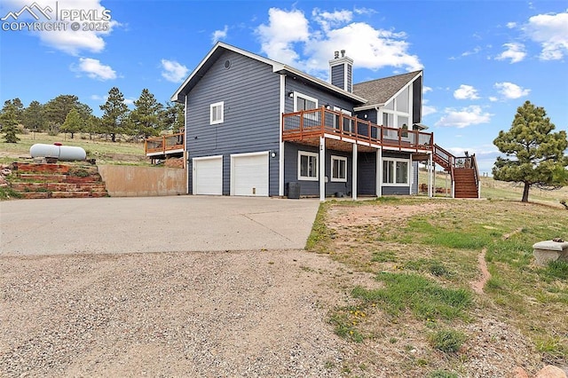 17880 Plains Edge Ct, Peyton, CO 80831 - back of property featuring driveway, a chimney, a wooden deck, an attached garage, and stairs