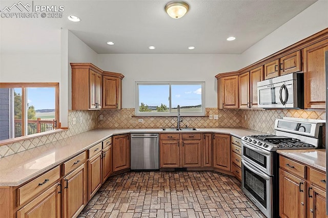 17880 Plains Edge Ct, Peyton, CO 80831 - kitchen with a sink, brick floor, a healthy amount of sunlight, and stainless steel appliances
