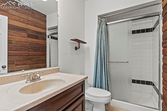 17880 Plains Edge Ct, Peyton, CO 80831 - full bathroom featuring vanity, toilet, wooden walls, and a stall shower