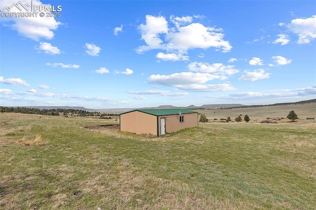 17880 Plains Edge Ct, Peyton, CO 80831 - view of yard with an outdoor structure, a pole building, a mountain view, and a rural view