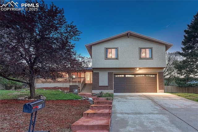 26 Mountain View Rd, Manitou Springs, CO 80829 - view of front facade with an attached garage, fence, concrete driveway, and brick siding