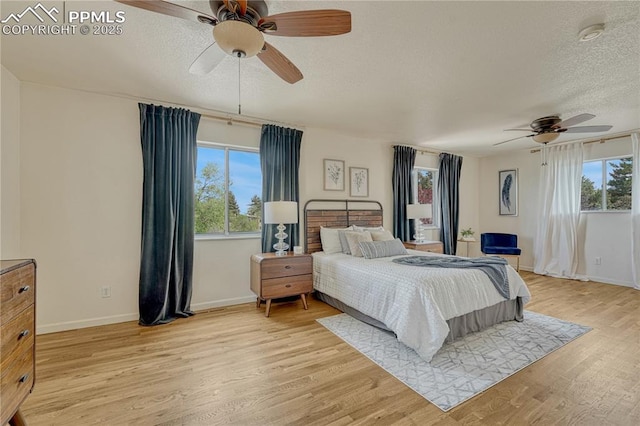 26 Mountain View Rd, Manitou Springs, CO 80829 - bedroom featuring a textured ceiling, multiple windows, light wood-type flooring, and baseboards