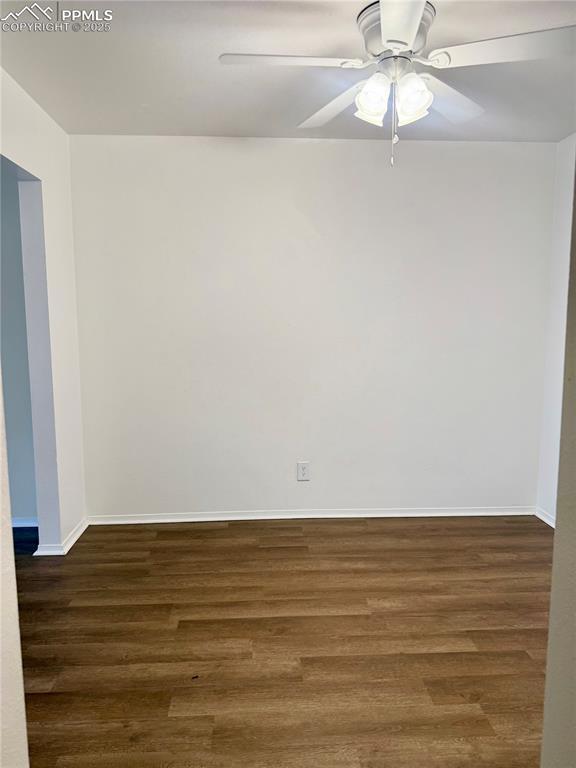 empty room with baseboards, ceiling fan, and wood finished floors