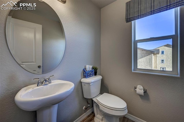 7352 Cornice Pt, Colorado Springs, CO 80923 - half bathroom with a sink, baseboards, toilet, and wood finished floors
