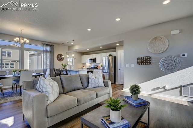 7352 Cornice Pt, Colorado Springs, CO 80923 - living room featuring recessed lighting, a chandelier, and wood finished floors