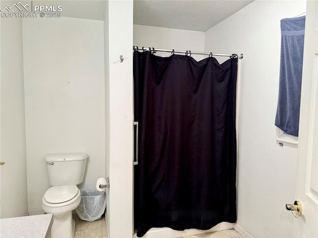 1322 Lincoln Ave, La Junta, CO 81050 - full bath featuring a textured ceiling, tile patterned flooring, toilet, and curtained shower
