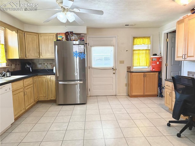 1322 Lincoln Ave, La Junta, CO 81050 - kitchen with visible vents, freestanding refrigerator, dark countertops, white dishwasher, and a sink