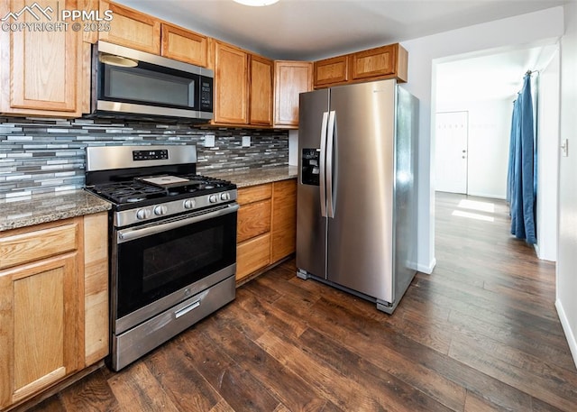 1328 E Las Animas St, Colorado Springs, CO 80910 - kitchen featuring dark wood-type flooring, appliances with stainless steel finishes, backsplash, and light stone counters