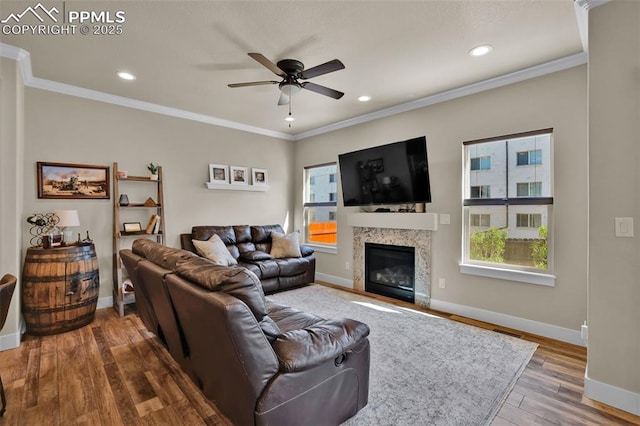 835 Redemption Pt, Colorado Springs, CO 80905 - living room with baseboards, a glass covered fireplace, ceiling fan, crown molding, and wood finished floors