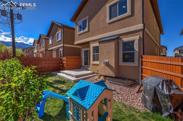 835 Redemption Pt, Colorado Springs, CO 80905 - rear view of property with a fenced backyard, stucco siding, and a mountain view