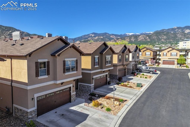 835 Redemption Pt, Colorado Springs, CO 80905 - view of front of house with stone siding, stucco siding, a garage, and a mountain view