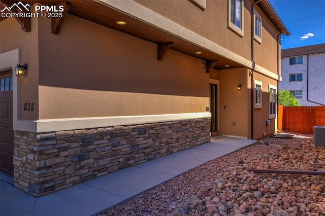 835 Redemption Pt, Colorado Springs, CO 80905 - view of property exterior with stone siding, stucco siding, and fence