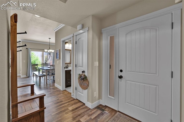 835 Redemption Pt, Colorado Springs, CO 80905 - entryway featuring wood finished floors, a textured ceiling, a barn door, baseboards, and a notable chandelier