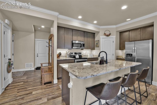 835 Redemption Pt, Colorado Springs, CO 80905 - kitchen with wood finished floors, a sink, dark brown cabinetry, visible vents, and appliances with stainless steel finishes
