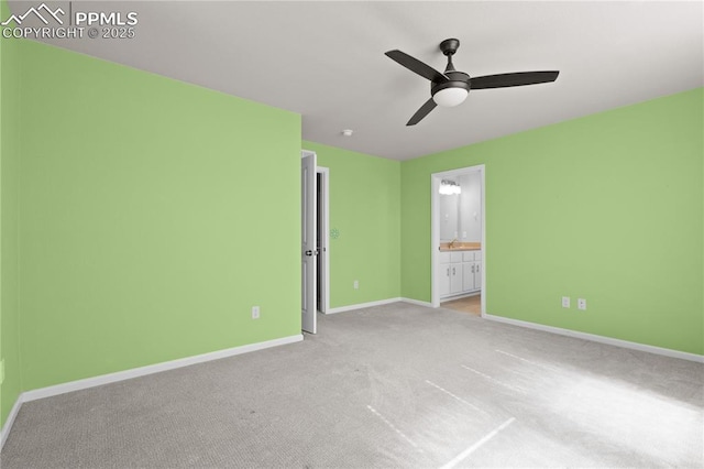 unfurnished bedroom featuring baseboards, carpet flooring, connected bathroom, and a ceiling fan