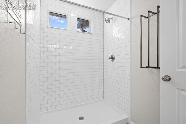 bathroom featuring a stall shower and a textured wall