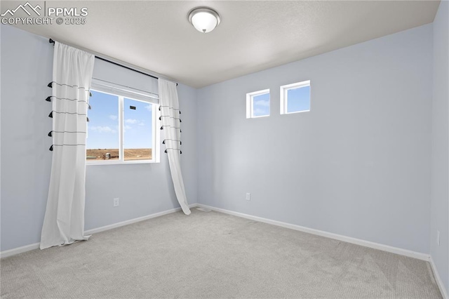 empty room with baseboards and light carpet